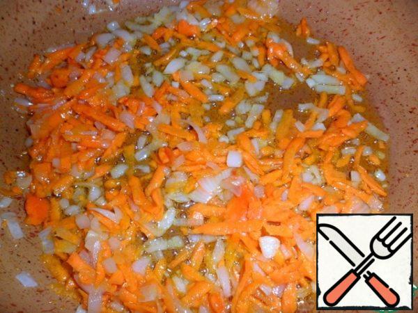 In the meantime, prepare a dressing for pickle. Finely chop the onions and grate the carrots. Fry in a heated pan with oil, just a couple of minutes.