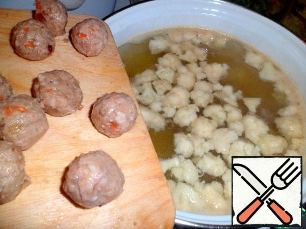 Meanwhile, add to the potatoes disassembled into inflorescences cauliflower and meatballs. Continue to cook for 10 minutes.