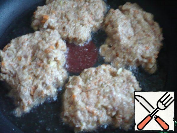 In a frying pan pour vegetable oil, heat it and spread the prepared minced meat with a spoon in the form of fritter.