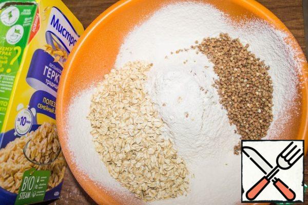 In a deep bowl, mix the sifted flour, oat flakes and swollen buckwheat.
