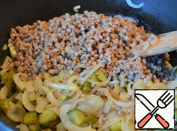 Onions fry in vegetable oil until transparent,
add cucumbers, cook for 3 minutes.
Put half of the cooked buckwheat, mix well.
Fry for 3 minutes.