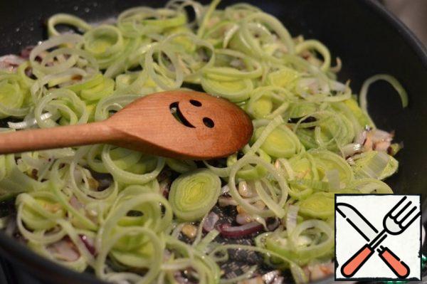 Cut the leek into rings and add to the fried onion.
Stir and fry for 1-2 minutes.