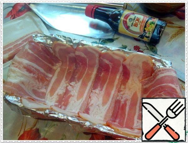 For a festive look and aroma of smoked products we cover the form with strips of smoked bacon. If you do not use bacon, you can just grease the form with oil, so the dish will not only festive, but also dietary!