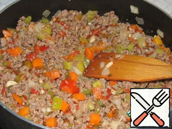 Then add there frozen vegetable mixture (I had "Lecho: bell pepper, tomatoes, carrots, onions), garlic, season with salt and pepper. Fry for 10 minutes and allow the filling to cool slightly.