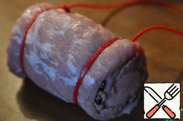 Roll the roll.
Fasten the roll with kitchen thread or special rubber bands for meat.
Start with the edge to the filling remained in place.