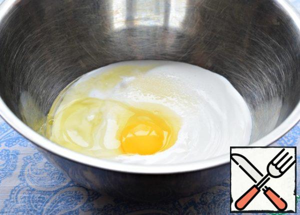 In sour cream (or thick natural yogurt), beat an egg, add sugar, a pinch of salt and soda. Mix thoroughly with a spoon or spatula. A mixer is absolutely not needed here.
Be careful with salt, the cheese is quite salty.