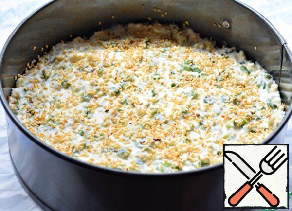 Cover the bottom of the detachable baking dish (20 cm in diameter) with baking paper. Lubricate the walls and bottom of the mold with vegetable oil.
Put the dough into a mold, smooth it out. Sprinkle the cake with sesame seeds (or poppy seeds).