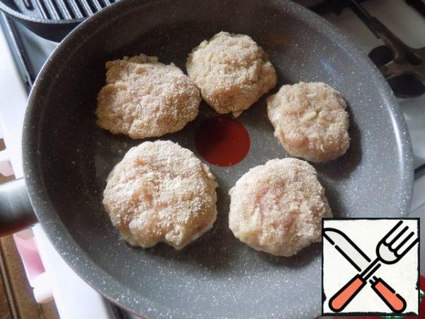 Fry the cutlets. In the pan pour sunflower oil and heat it. Spread the cutlets. Fry the cutlets on one side to a beautiful crust, reduce the heat to medium.
