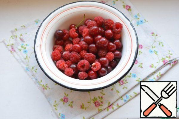 Wash raspberries and cherries and throw them on a sieve.