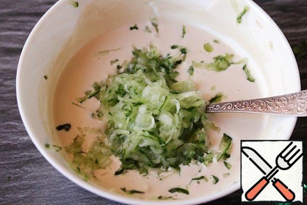 Add the cucumber, grated on a coarse grater.
I rub it right into the yogurt to preserve the juice from the vegetables. If you want the sauce to get thicker, grate the vegetables in another bowl, and then squeeze out the juice.
