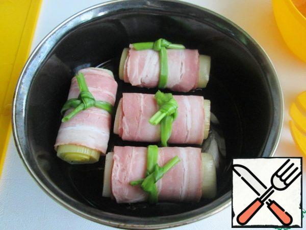 Add 2-3 tablespoons of vegetable oil to the mold, lubricate the sides. (Optionally, you can add 2 tablespoons of water or broth). Lay out the "barrels". Cover the mold with foil and put it in a preheated oven (180 *) for 15-20 minutes.
