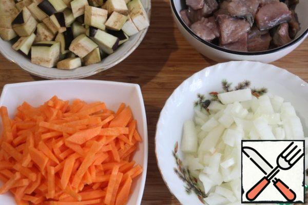 Peel carrots, wash and cut into strips.
Cut the eggplant into a small cube.
Peel and dice the onion.
Fillet mackerel cut into small pieces.