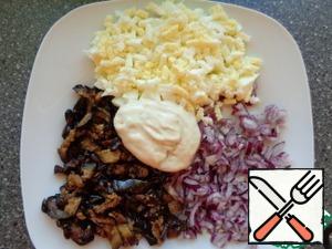 Cut eggplant into strips, fry in vegetable oil until Golden brown. Boil the egg for 10 minutes. Red onion finely chopped. Put on a dish, add mayonnaise.