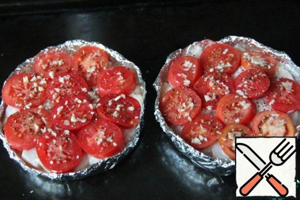 Cover with rings of tomatoes. Add garlic, pepper.