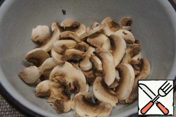Remove the skin from the mushrooms and cut into thin plates (caps only).
