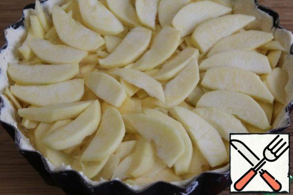 Apples peel and seed boxes, cut into thin slices.
We take out the form of the freezer and spread the apples.