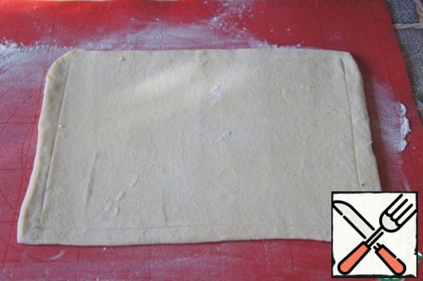 Defrost the dough. Heat oven to 220 * C.
Place the dough on a baking sheet and slightly cut along the perimeter, not reaching the edges of about 1.5 cm.