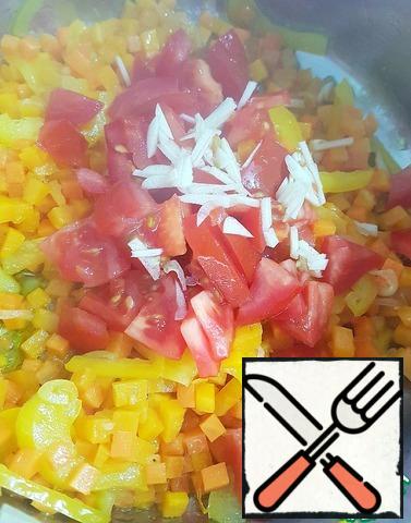 Tomatoes cut into convenient for you way, garlic chopped. Add to vegetables, stir and fry for a couple of minutes.