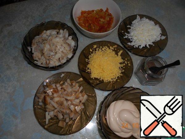 Pollock is disassembled into pieces, removing the bones and skin. Boil the egg, separate the yolks from the proteins, the yolks three on a small grater, proteins on a large. Mushrooms are salted, marinated, finely chop. Take the beans without liquid.