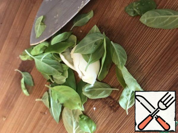 The garlic and the Basil leaves chopped with a knife, fish slice or mash with a fork. Add to sauce.