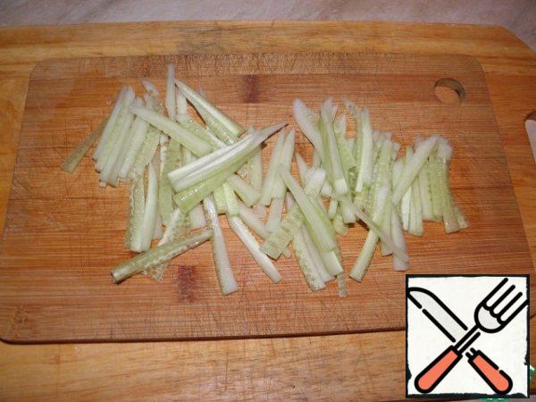 Wash the cucumber, peel and cut into thin strips.
