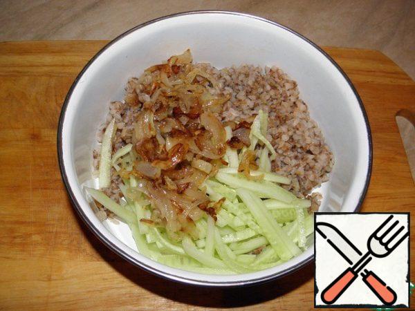 Add fried onion and cucumber to the buckwheat porridge, mix, add salt and pepper to taste.
