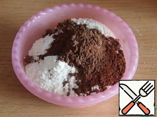 Add egg yolks and odorless sunflower oil to the whites one at a time. Sift the flour with baking powder and cocoa. Stir, if the dough turns out very thick, add one or two tablespoons of milk.
