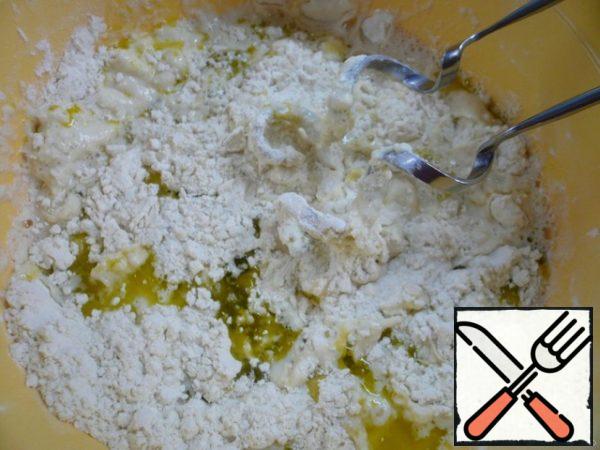 Mix flour with semolina, yeast crumble between the palms and spread evenly over the surface of the flour. There also add salt, water and olive oil.