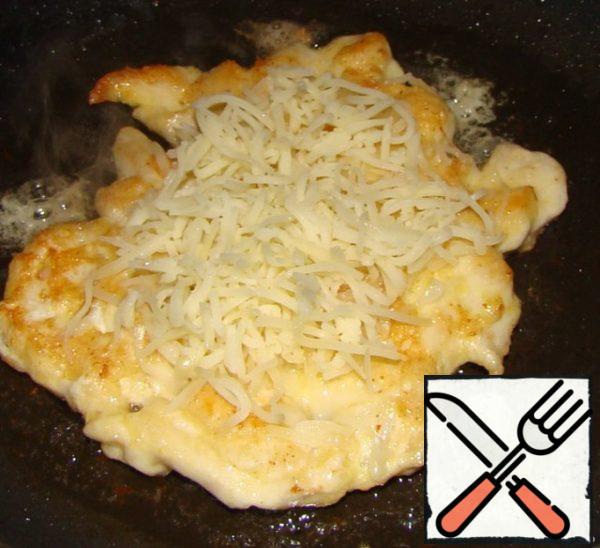 At the same time on the second pan I fried chicken cutlets. Fry on one side ,turn over..Fry until tender on the other side.now, pay ATTENTION. Once again, turn over and sprinkle with a little grated cheese .Hold on a little in the pan that would cheese melt. 
