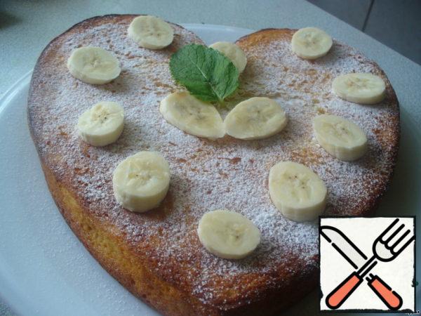 We shift the cake to the dish. Sprinkle through a strainer with powdered sugar. Cut the third banana slices, sprinkle it with lemon juice (not to darken), decorate their cake.