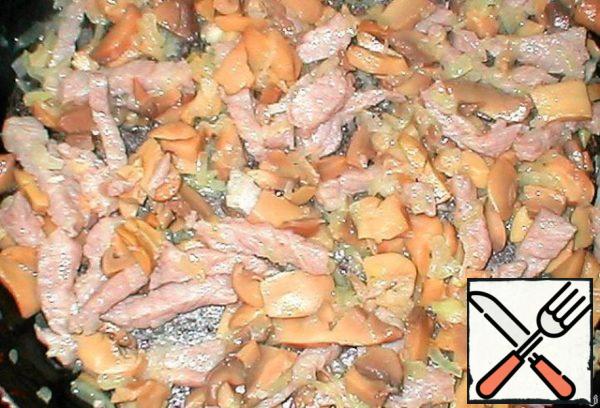 Finely chop the chicken fillet, season with salt and pepper, you can add seasoning for chicken, sprinkle with a small amount of vegetable oil.
In a frying pan, fry the chicken, bacon, if desired - finely chopped onion, mushrooms (your favorite).
