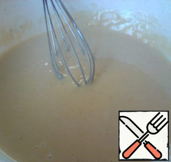 Mix the flour with baking soda and sift into a cup. Stir with a whisk until smooth. The dough should turn out without lumps, fluid - a little thinner than the dough for pancakes.
