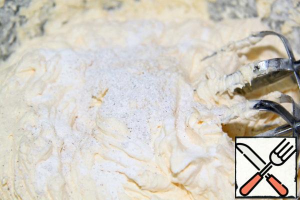 Add half of the flour, slowly adding, add baking powder and vanilla sugar.
Mix everything and add the remaining flour.
