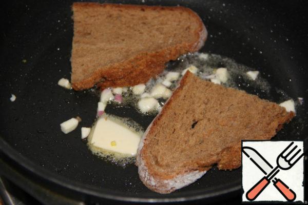 Rye bread cut into slices. Heat the oil in a frying pan, add the garlic pieces. Fry the bread on both sides. Take out on a kitchen towel and allow to drain the fat.
Repeat several times.