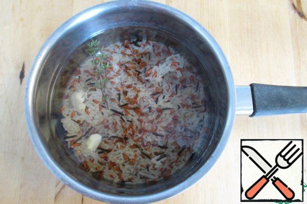 Rice boil in boiling water for 10 minutes, adding a pinch of salt, thyme (0.5 tsp), 1 clove of garlic, peeled and crushed with the side of the knife.