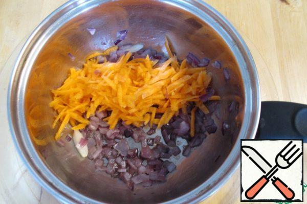 While the terrine is baking, we will prepare a simple but delicious sauce that will decorate the rice. Finely chop the onion and garlic clove, fry together until the onion becomes transparent. Add grated carrots, fry for another 3-4 minutes.
