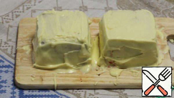 Beat 50 g butter until foamy. Continuing to whisk, add 50 g of melted butter. Beat the mixture until it becomes homogeneous and dense enough. Carefully turn the form with prepared terrine upside down on the cutting Board and release it from the form. A wide knife or a spatula to cover terrine with whipped butter-on top and sides.