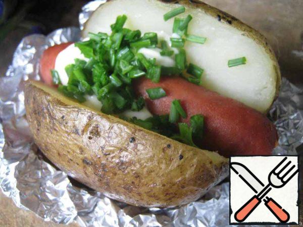 In the cut potatoes put a spoon of sour cream (yogurt or mayonnaise), sprinkle with herbs, green onions. Fans can add the ketchup. And put on top of the baked sausage.
Snack for youth picnic is ready!