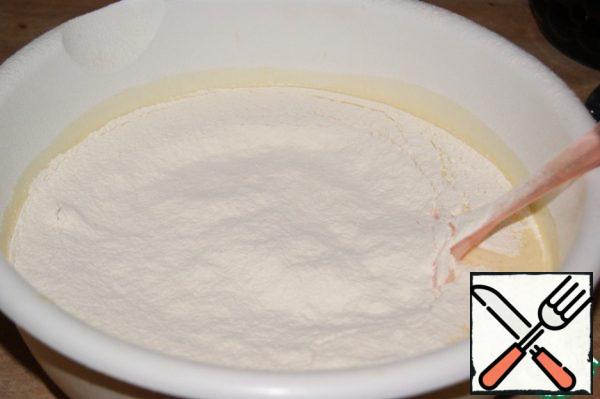 Add flour mixed with baking powder and vanilla and sifted.