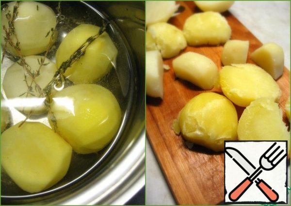 Wash, peel and boil potatoes in salted water with cumin for 20 minutes. (I mixed up the herbs and added thyme instead of cumin.)
Drain the water. Cool the potatoes and cut the tubers in half.