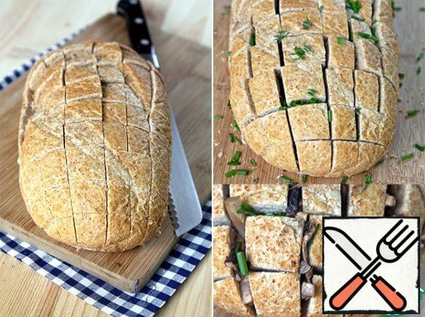 Now take bread. Some fresh, delicious loaf... And carefully cut into squares, a little before reaching the end. Then pour the sliced onion and thyme leaves, carefully lay the mushrooms...