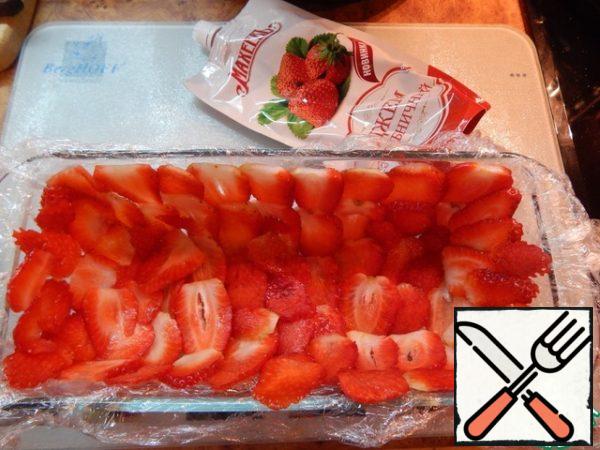 Cover the mold with a volume of about 1 liter with cling film and lay the strawberries (cut into plates) on the walls overlap.
