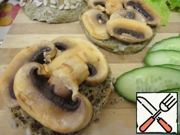 Start collecting buns. Lay out the vegetables in layers, pickled mushrooms first.
