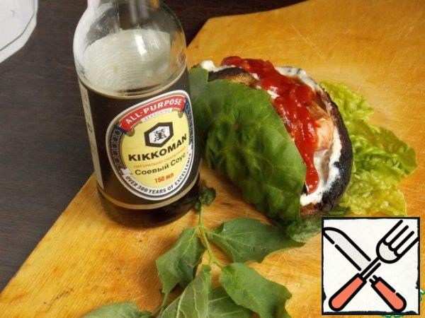 Mix mayonnaise with green onions, mustard and spices. It's gravy. Cut the warm potatoes to the middle and remove part of the potato. Put a spoonful of sauce inside and put a sausage on top. Pour over the ketchup and wrap it in lettuce leaves for convenience.