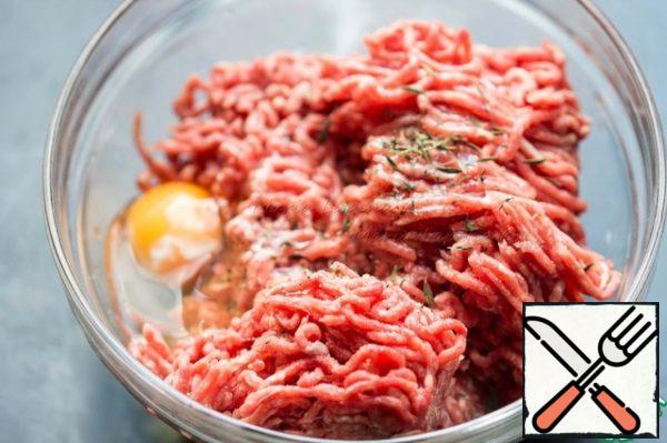 Season the minced meat with salt and pepper, add the egg and thyme leaves. Knead the minced meat with your hands.
