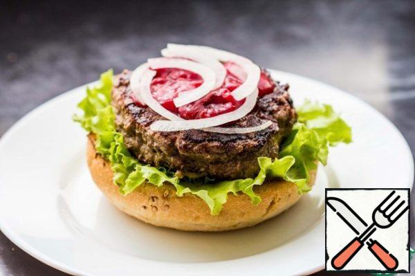 Forming a Burger. On a bun, put a leaf of lettuce, then finish the Burger. Pour it 1 tablespoon of sauce, put the onion on top.