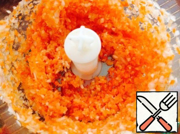 Onions and carrots break in a blender.