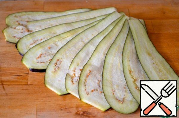 Eggplant and zucchini cut lengthwise into layers of medium thickness. Place on separate baking sheets, greased with olive oil. Using a brush, brush the chopped vegetables with olive oil. Bake until tender for about 10 minutes.
