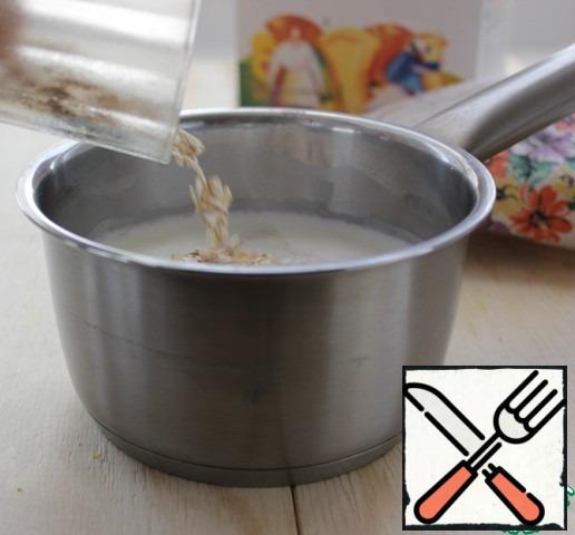 In a saucepan pour the milk, put on the stove, bring to a boil. Pour oat flakes into hot milk and allow to cool to room temperature.