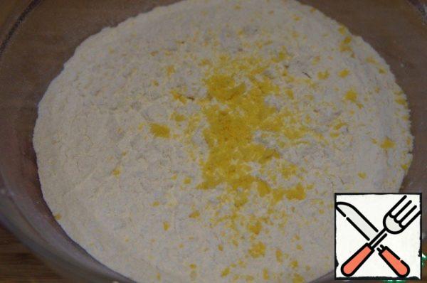 Sift the flour into a larger bowl. Rub the lemon zest on top.
